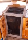 This shows the main companionway bug screen.  The "frames" are stitched up out of scrap Sunbrella from the Iverson dodger and bimini.  The screen is from Home Depot for sliding glass doors.  There are wooden slats spanning the forward and aft edge of the top.  The whole thing is held in by gravity using galvanized chain as weight in the sides of the top and the bottom edge of the door.  The chain is held in to pockets with snaps so it can be removed and replaced if it gets rusty.