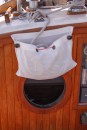I found some scrap mesh left up by the garbage and turned it into this line bag for the main sheet.  This picture also shows the new bug screen in the galley porthole.