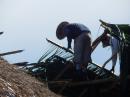 Workers putting on a new thatched roof