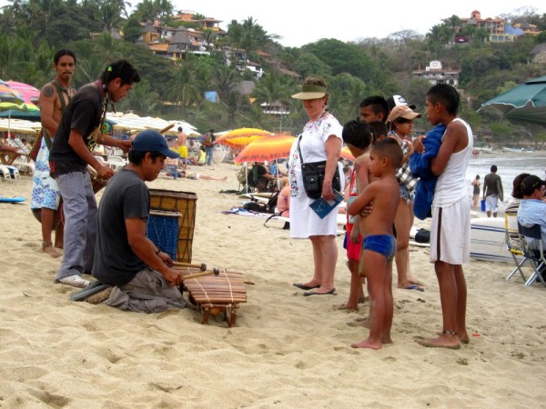 local young men playing music on the beach