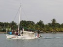 Typical Belizian fishing boat loaded with lots of small canoes and about 10 fishermen.