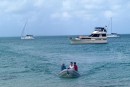 Michael, Deb and John coming ashore to meet up with us at the dinghy dock.  Our boats are anchored in the background.  The Catamaran on the left belongs to Michael and Deb and our boat is the S/V on right.