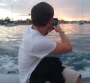 Taking a picture of the sunset to send to his girlfriend.