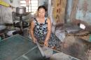 This woman sits in front of a hot cooker 10-12 hours a day making rice crackers.