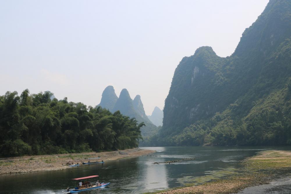 From Guilan we took a day cruise up the Li River.  It is very touristy and when we arrive there were at least 50 boats and many hundreds of people.  I thought this will not be a good day but it was excellent.  Each boat only takes about 50 people each with assigned tables and seats,  air conditioning inside.  Lunch and snacks were included and the guides gave running commentary in English and Mandarin.

Once we left the dock the boats were spread out and the scenery became expansive.  The river winds through miles of mountainous terrain,  past small villages, and locals working the river.  The trip lasted about 4 hours and was worth the modest cost.