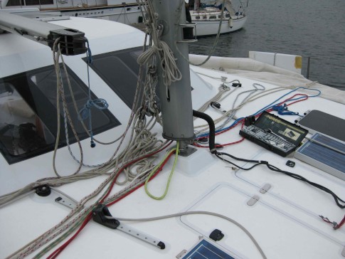 The sails are stripped off, the boom is laying on the cabin top, and the lines are all loosened. Also the wiring harness has been cut to allow the mast to be raised.