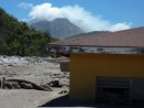 Abandonded house in the path of the volcano flow with ash and rocks that have washed down from the above to the shore