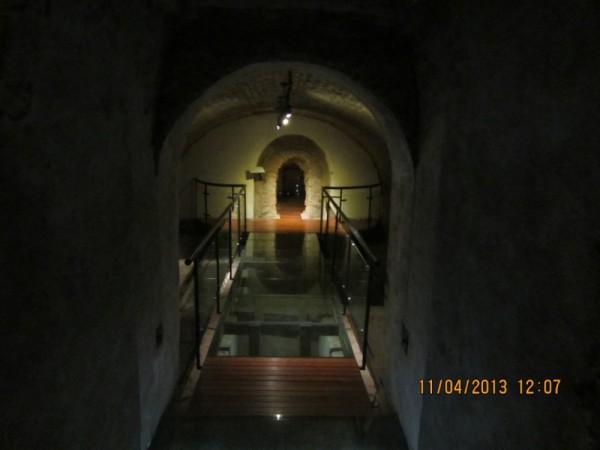 Underground hall with catacombs seen through the glass floors.