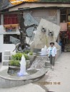 Gail by a fountain and statue with a condor and a puma, two of the important animals in the Inca world.