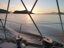 Sun setting through Breaksea Island as Barefoot enters Bramble Cove, Pt Davey