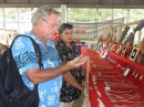 Before leaving Neiafu, Jim selects a Tongan carved bone fish hook necklace from the local veggie and  craft market.