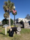 A lamp post gets a holiday wreath to dress up this median strip with old Spanish cannon.