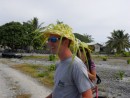 A passing tourist displays the hat he made from palm fronds.