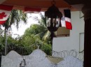 A DR Collage: old-style lantern, Dominican flag, Canadian flag, lush vegetation, palm trees, barbed wire and concrete. (Sparkys. Sosua, Dominican Republic)