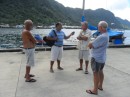 Jeff, second from left, interviews dockside cruisers (from left) Mac (Honu), Jim, and Mike (Honu). When the article came out in the paper, MWR representatives came to the dock and told us we had to leave that day or they would come back and cut our docklines at 4:00 p.m. Hence the dock war began. (To read more, go to www.samoanews.com and look up the articles in the Friday, June 17 and the Saturday, June 18 issues. Photos of Jim and of Cactus Wren are included.)