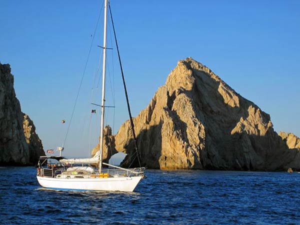 Due West rounding the tip of Baja and headed for Cabo, arch in the background. Photo courtesy of s/v Windcharmer. 
