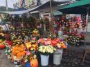 Flower stands fill the streets outside the cemetery, where families come for days before Nov. 2nd to paint, white-wash, clean-up, and decorate their family graves. In PV