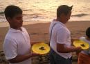 The kids line up with little plastic trays like frisbees, and each one gets a sea turtle to release. Then it