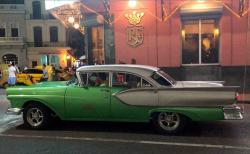 A flashy green and silver 1957 Ford sits in front of the Floridita, Hemingway