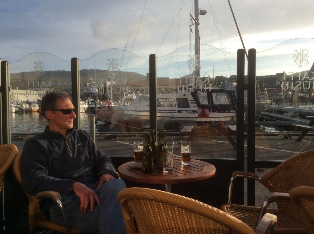 Pondering the passage to Iceland while enjoying the evening sun and the local beer in Torshavn : Kiviuq is in the near background behind the small power boat.  A handy spot!