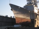 A naval ship in drydock - totally lifted out of the water