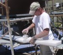 Tom sanding the wind vane self steering gear rudder which was Awlgripped to match the hull.