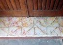 The threshold of the home with pink and green marble; teak door